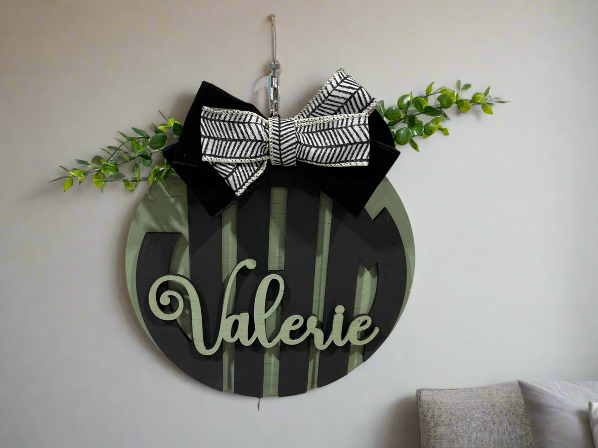 Decorative wall sign with a black bow and the name 'Valerie' (customizable, paint yourself)
