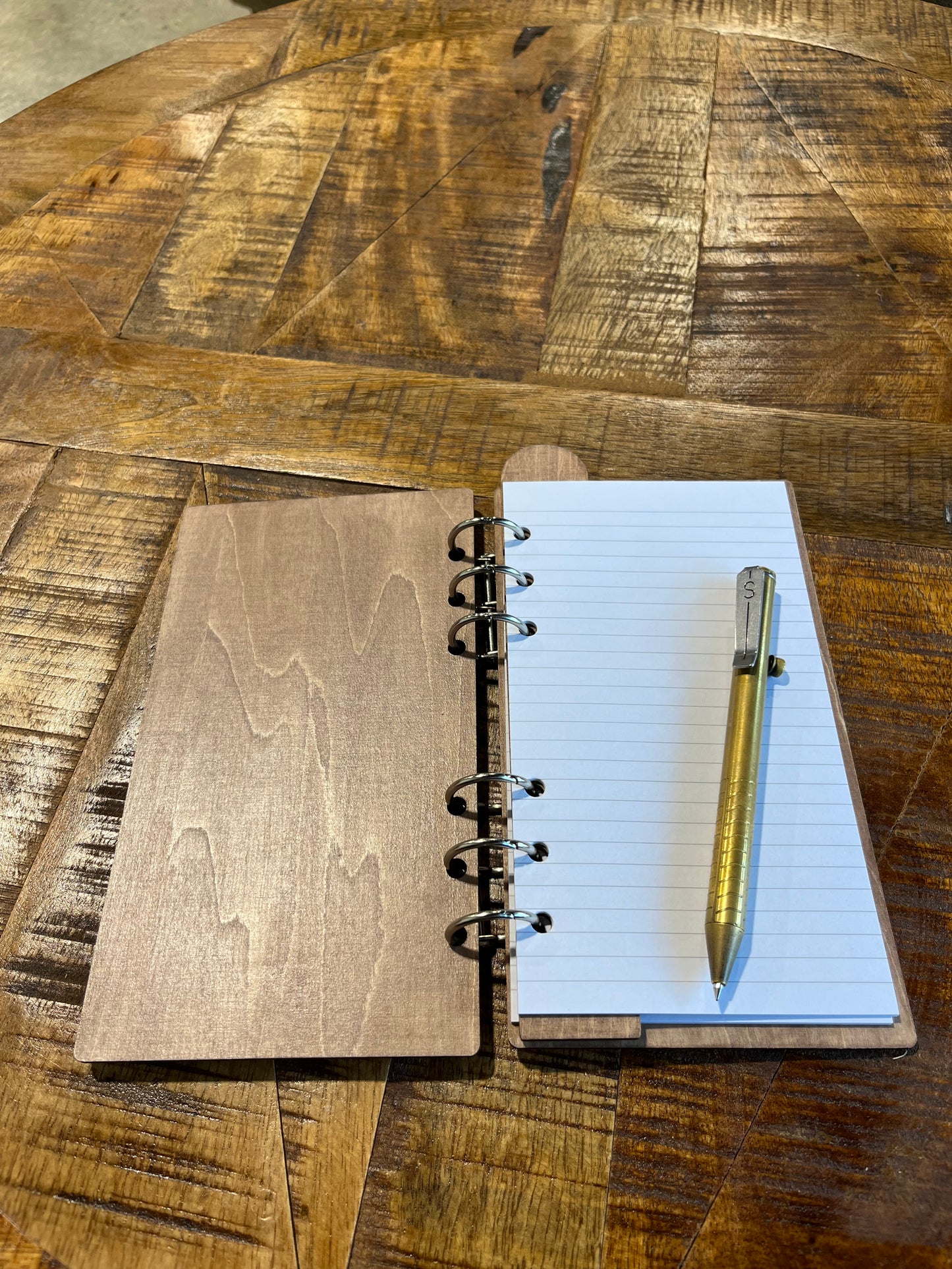 Open notebook with laser-cut wood frame. Lined pages inside.
