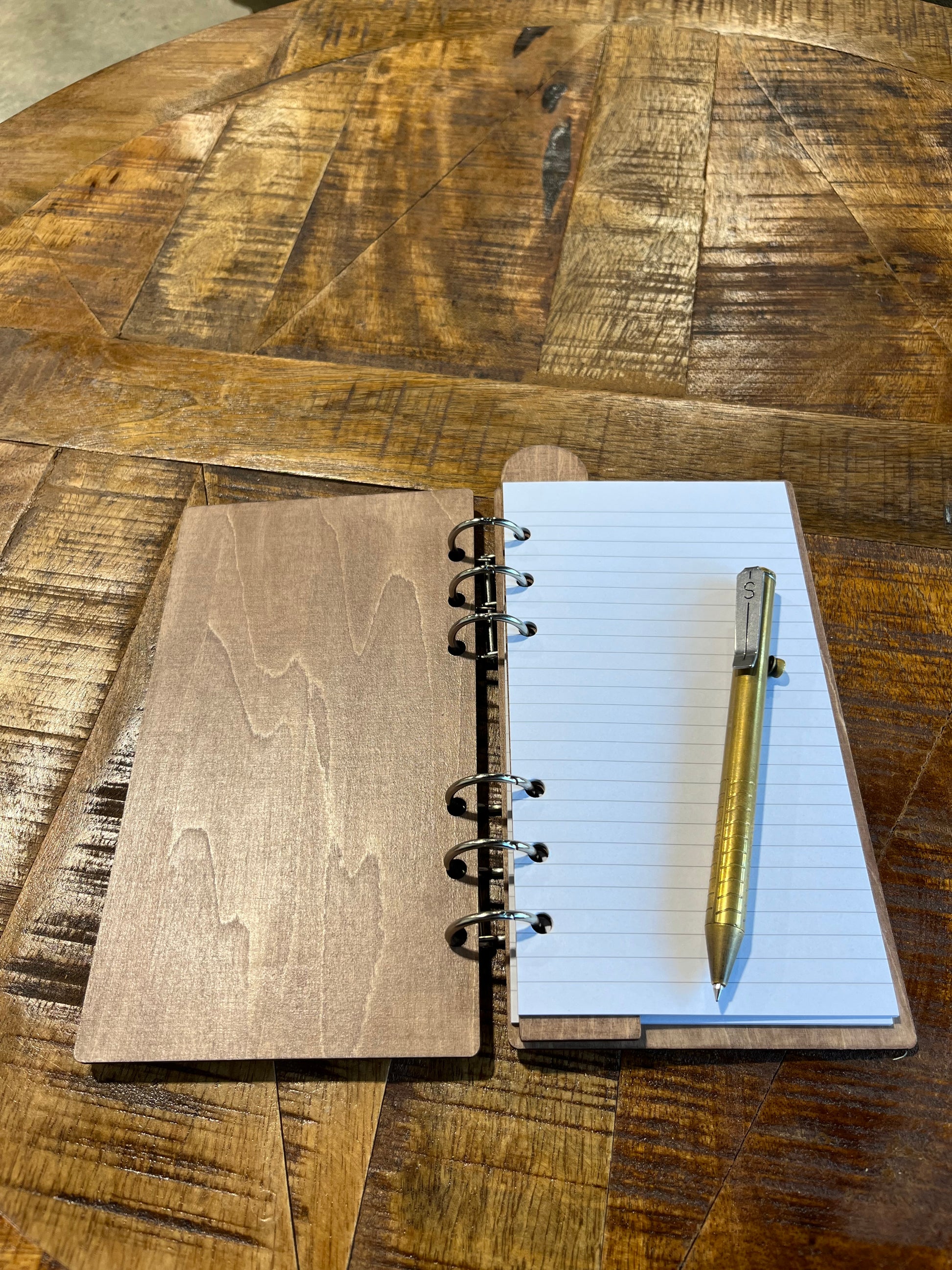 Open notebook with laser-cut wood frame. Lined pages inside.