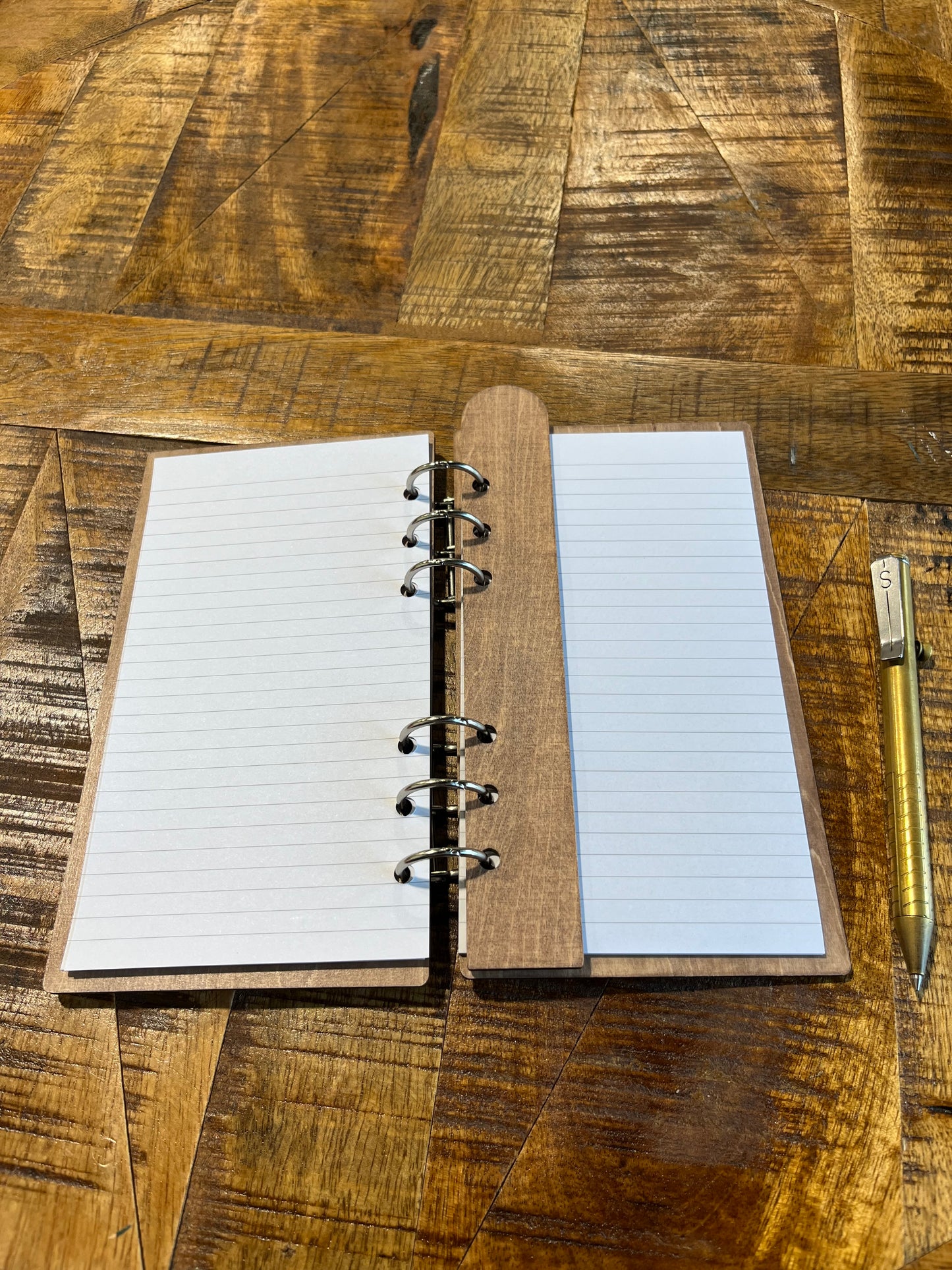 Open notebook with laser-cut wood frame. Lined pages shows with laser-cut bookmark on inside.