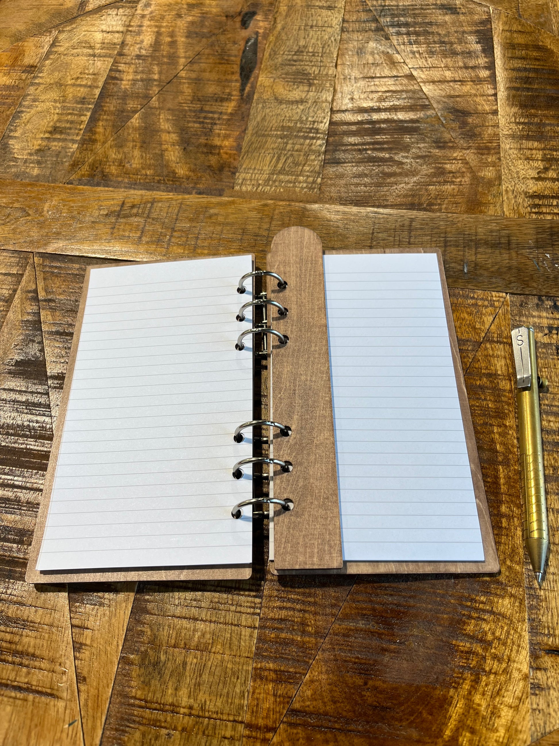 Open notebook with laser-cut wood frame. Lined pages shows with laser-cut bookmark on inside.