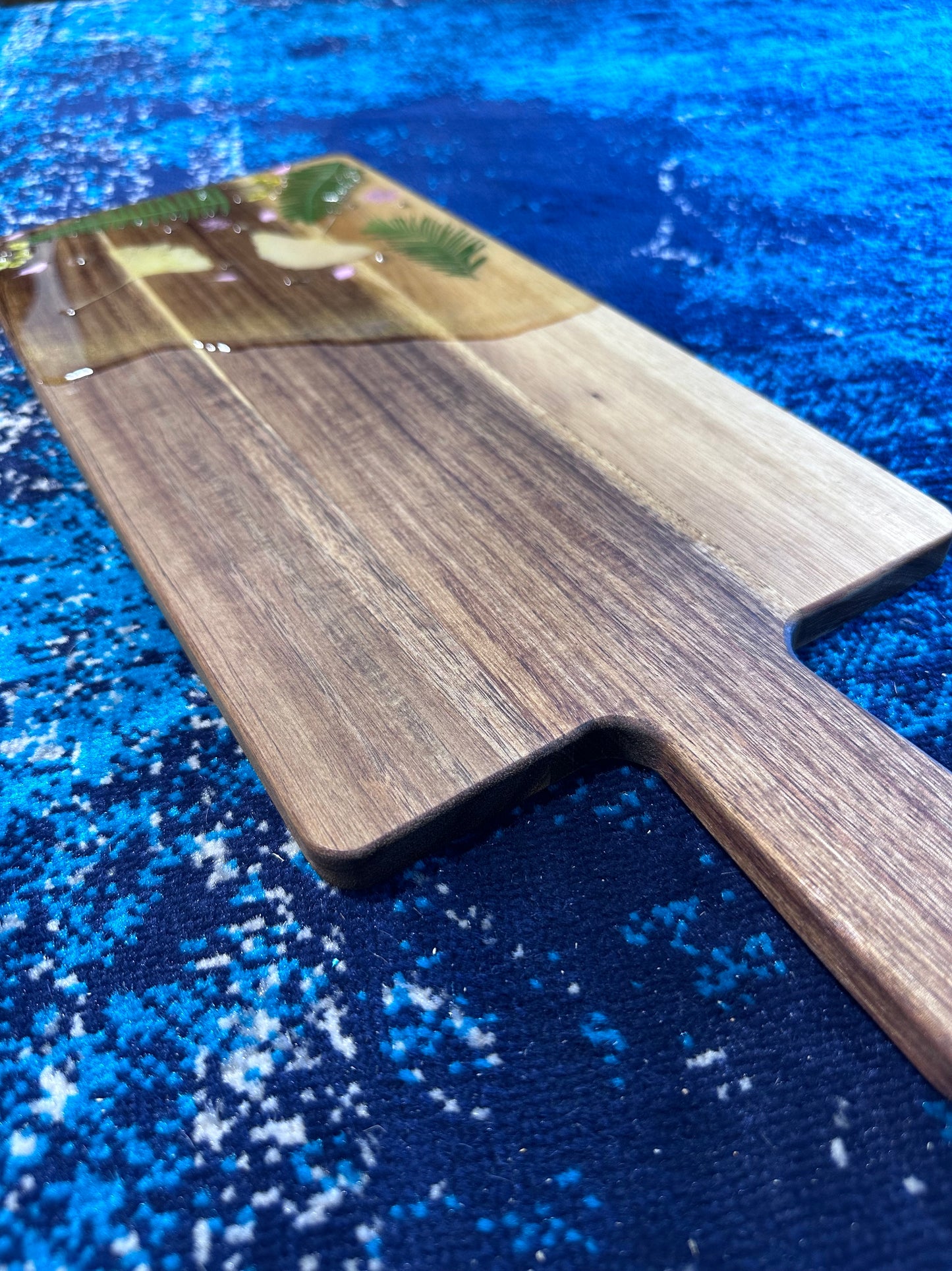 Close up of cutting board with pressed flowers; greenery and yellow/pink flowers