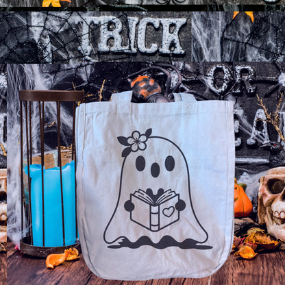 Design option a simple ghost holding a book with a heart on it. The ghost has a flower on its head.