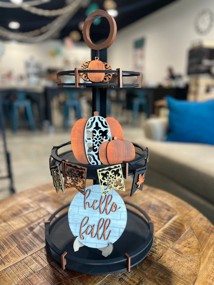 Decorative stand with DIY fall decor on it, pumpkins, hello fall sign, and garland with leaves on it.

