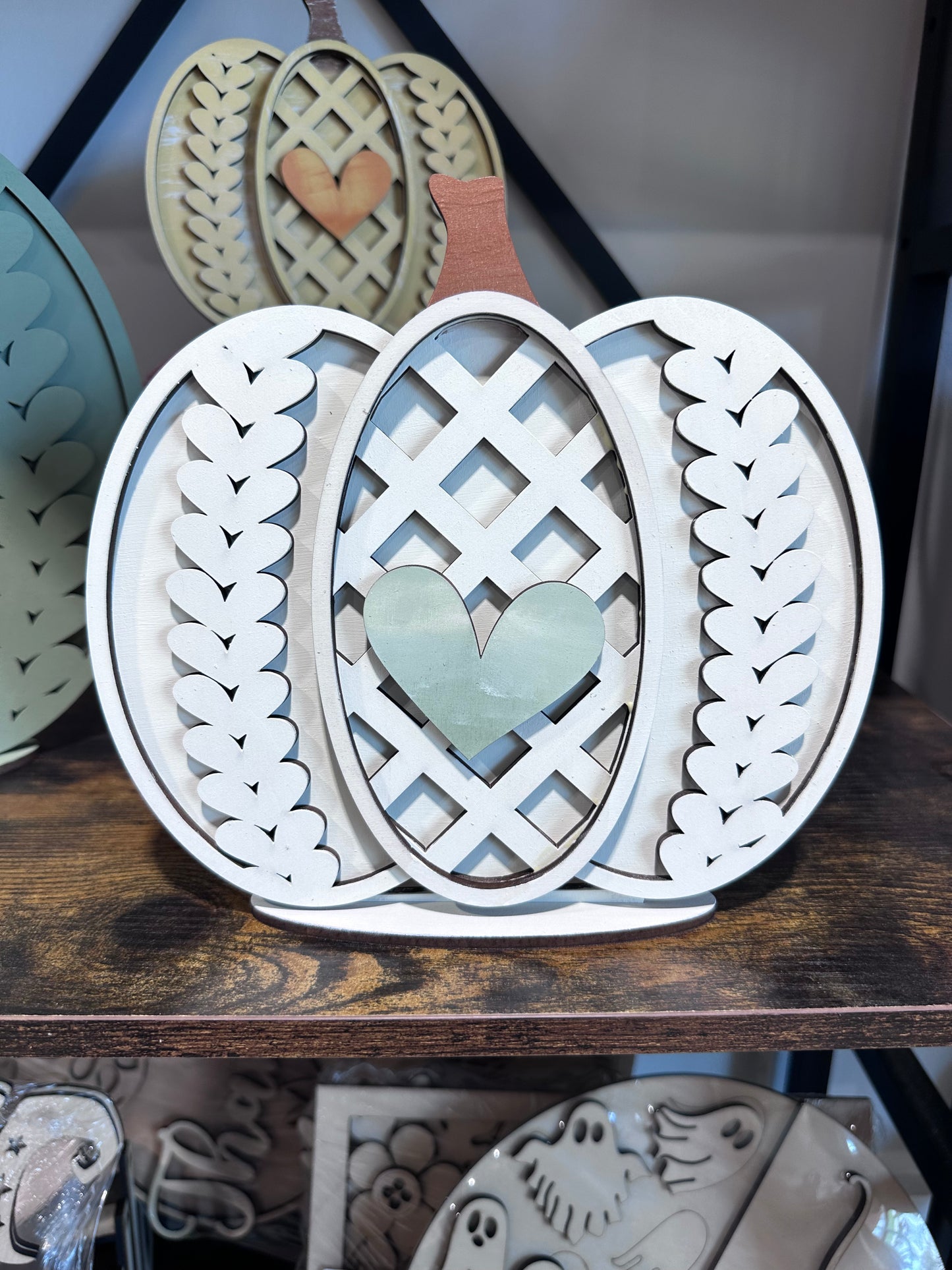 White pumpkin that you can paint yourself. It has a sweater pattern and a heart on the center