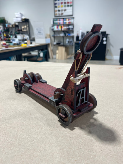 wooden DIY toy catapult finish and paint as you'd like example painted in a rustic distressed black and red