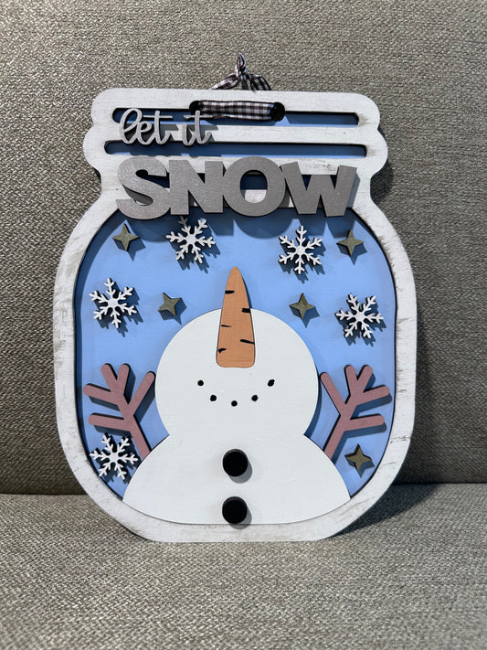 Mason jar shaped winter sign. Snowman looks towards sky catching snowflakes. Light blue background, silver sparkle details.