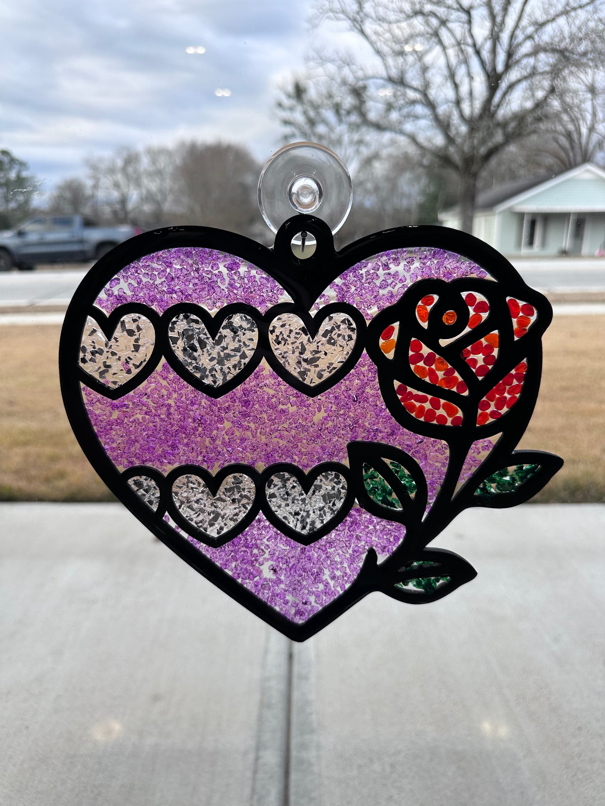 Decorative window cling with a colorful rose design on a glass door.