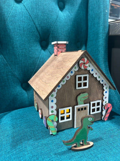 Laser cut gingerbread house featuring dinosaur figure